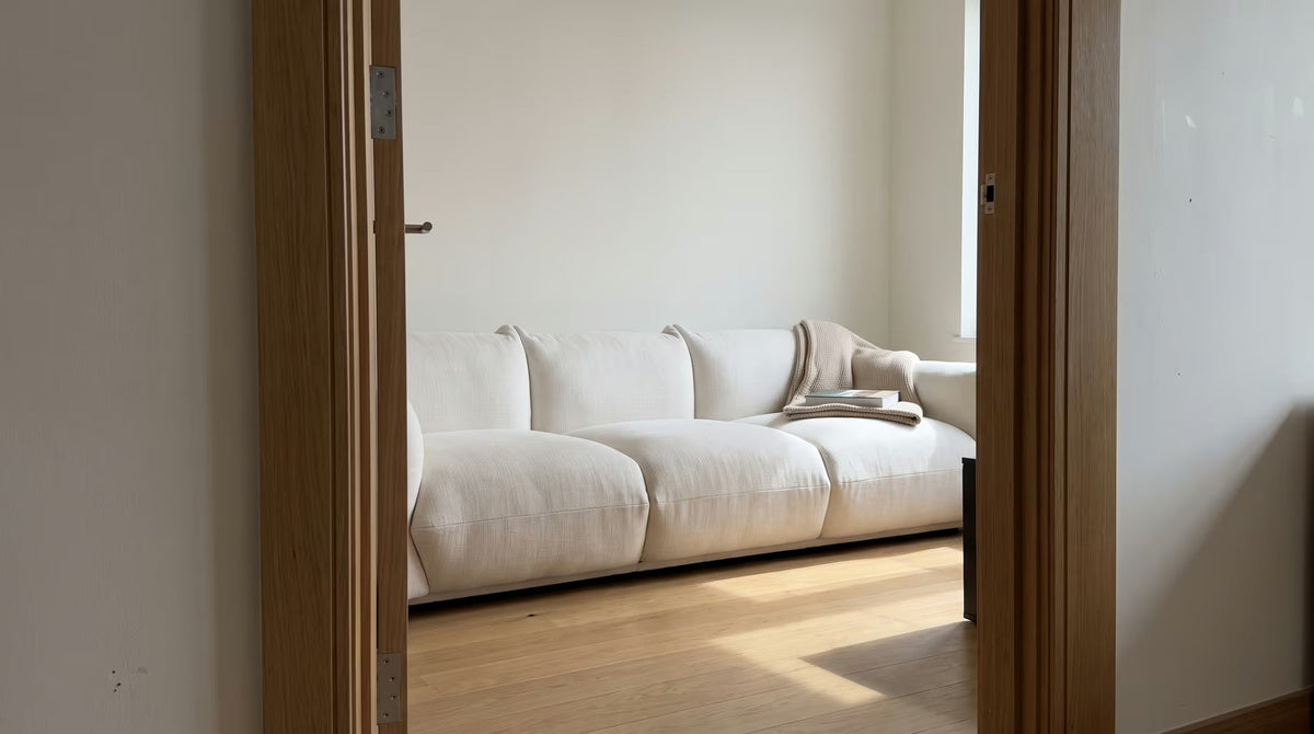 Ivory linen three-seater sofa seen through an apartment doorway