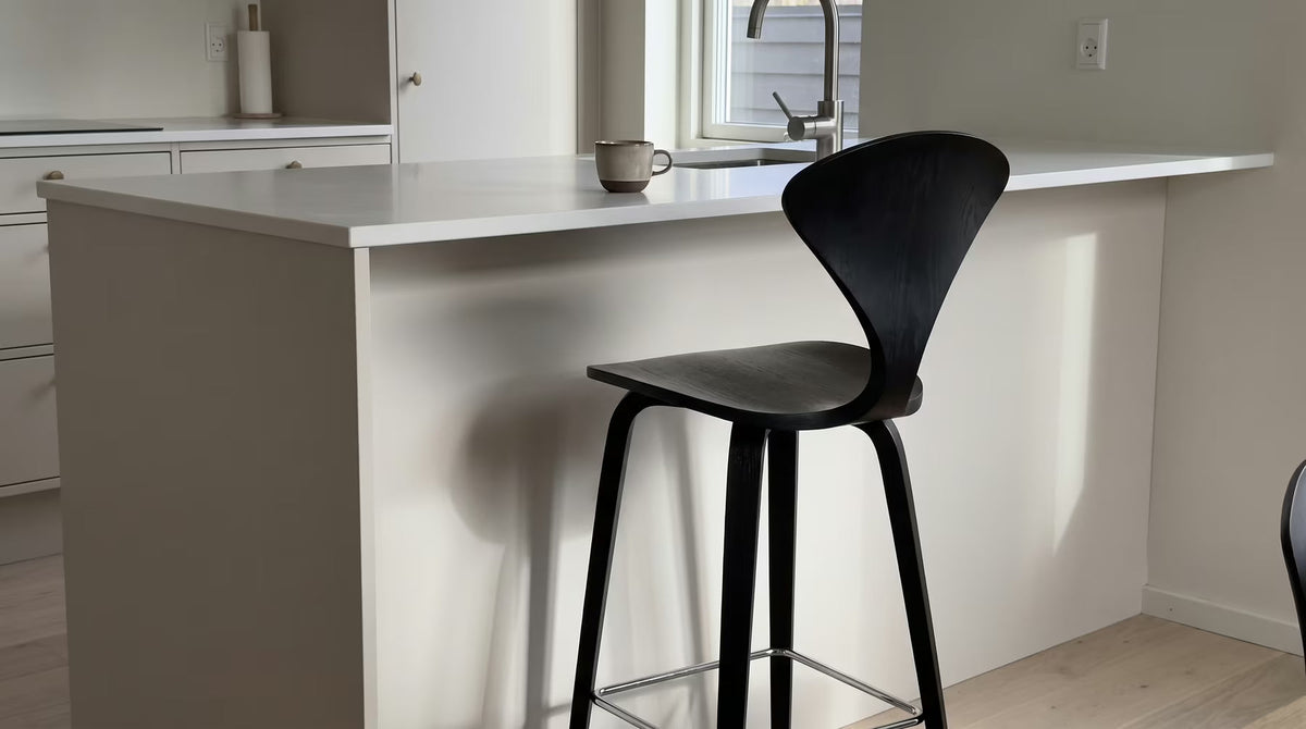 Black molded-wood counter stool beside a white kitchen island