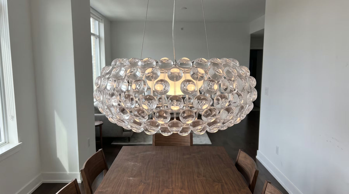 Sculptural ceiling light above a dark wooden dining table